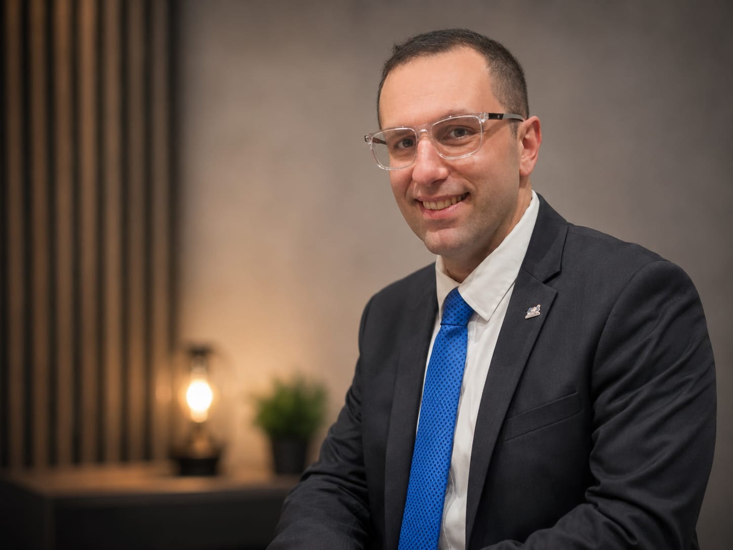 Charbel Tadros wearing a dark suit and blue tie